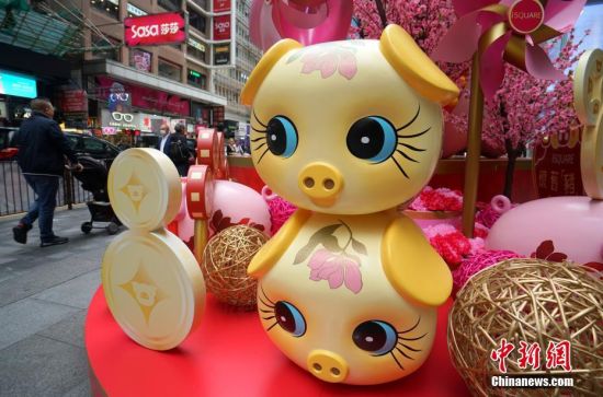 1月10日，随着己亥猪年临近，香港街头新春气氛渐浓，在车水马龙的尖沙咀闹市，商家提前搭好了猪年贺岁装置，一个个萌态可掬的“猪宝宝”吸引众多行人驻足观看拍照。中新社记者