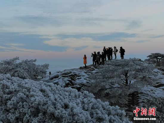 游客们行走于黄山峰峦之上，感受雪后美景。