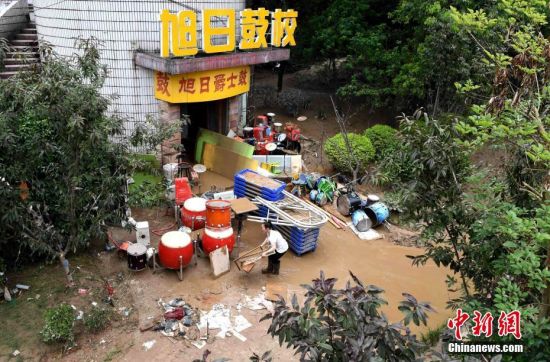 6月11日，洪水继续退去，福建三明城区被淹的培训学校工作人员正在清理被淹的物品。张斌