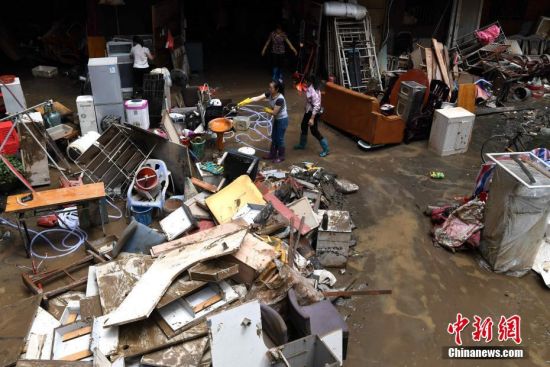 6月11日，洪水继续退去，福建三明城区一小区市民正在清理被淹物品。张斌