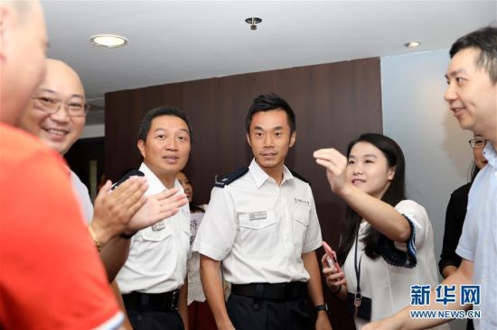 8月16日，香港市民在香港北角警署大楼和警察交流。新华社记者