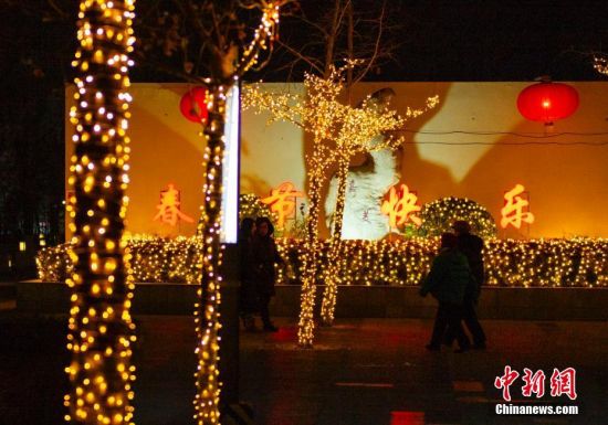 1月16日晚间，市民经过北京一处居民小区内的春节灯饰。春节临近，北京年味渐浓。中新社记者