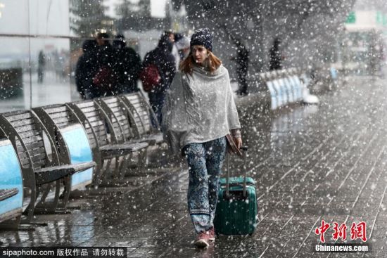 当地时间2019年10月6日，俄罗斯莫斯科，尚在金秋十月，莫斯科便已经飘起了初雪。洁白柔软的雪花如柳絮一般纷纷落在行人身上。图为在多莫杰多沃国际机场外行走的人们。图片来源：Sipaphoto