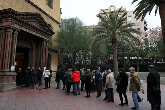西班牙民众在投票站排队投票。