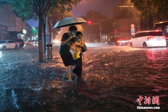 8月9日晚，北京市民冒雨涉水出行。当日，北京气象台发布18时至23时降水量（毫米）：全市平均17.9，城区平均28.1。中新社记者