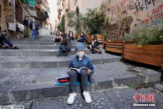 当地时间10月21日，意大利那不勒斯，学生们坐在石阶上学习，彼此之间保持社交距离。此前当地学校因新冠疫情暂时关闭。