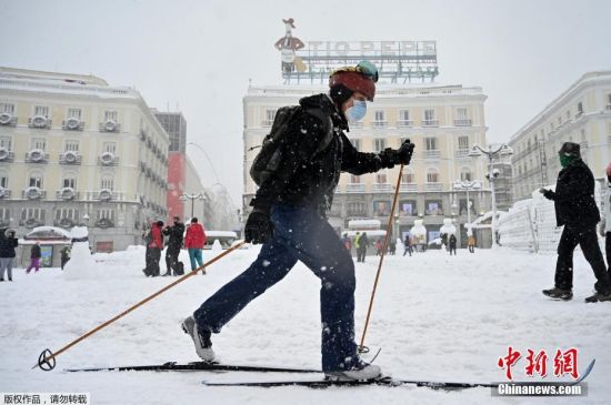 近日，受风暴“菲洛梅娜”影响，西班牙全国各地遭遇罕见大雪。暴雪引发首都马德里交通瘫痪，机场火车站等都被迫关闭。然而，大雪也带来了无限乐趣，不少居民拿着雪板雪具在街道上滑雪，整座城市仿佛变成滑雪场。图为当地时间1月9日，西班牙马德里，一名男子滑雪出行。