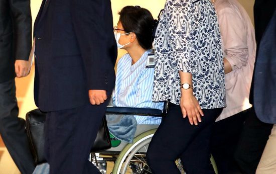 朴槿惠戴口罩坐轮椅前往医院将接受左肩手术。