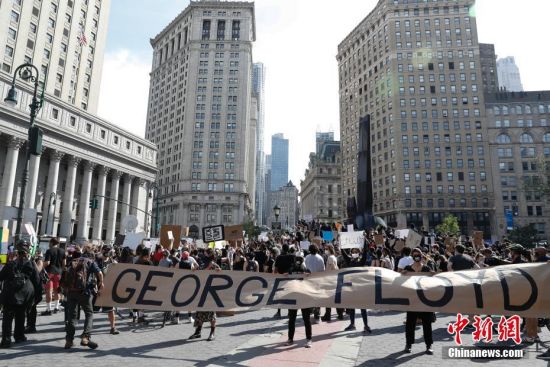当地时间5月29日，纽约上千民众聚集在曼哈顿佛利广场，抗议明尼苏达州明尼阿波利斯市非裔男子乔治·佛洛依德遭警察暴力执法致死。图为民众手持乔治·佛洛依德名字条幅。