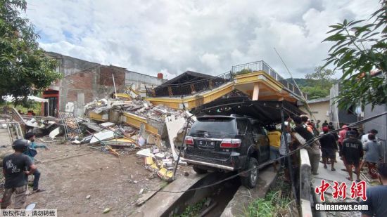 当地时间15日凌晨，印尼苏拉威西岛发生6.2级地震。目前，地震已造成至少42人死亡，数百人受伤，上千人流离失所。地震致震中所在的马杰内县和相距几十公里的西苏拉威西省首府马穆朱，灾情严重。包括省政府办公大楼、医院、酒店等在内的建筑在地震中严重损毁，大量民房倒塌。图为救援人员在马穆朱一座倒塌的建筑物内搜寻幸存者。