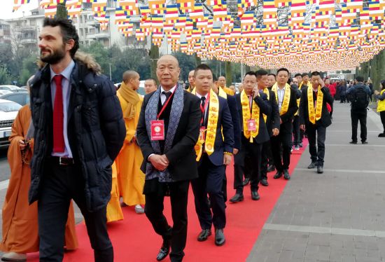 普拉托市市长马修·彼佛尼、意大利华侨华人佛教总会会长黄树林和僧侣、信众共同步入普华寺开光庆典法会会场。