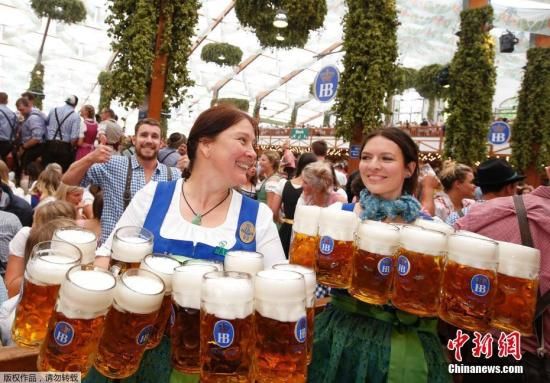 资料图为2017年慕尼黑啤酒节女服务员为食客端啤酒。