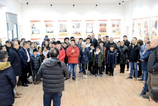 图片展讲解员向学生讲解中国改革开放40年所走过的发展历程。