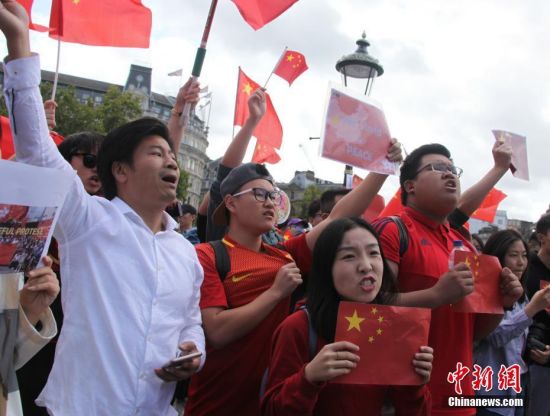 8月17日，旅居英国的华人华侨、中国留学生300多人自发聚集在伦敦市中心特拉法加广场、议会广场，与“乱港分子”组织的示威游行队伍对峙。人们挥舞中国国旗，高唱中国国歌，高喊“爱中国、爱香港”“反暴力、救香港”口号，声浪阵阵压过“乱港分子”阵营。图为现场群情激昂的华人青年。中新社记者
