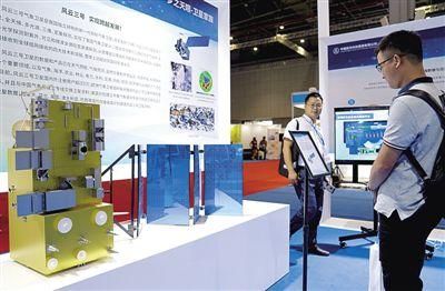 　　观众在第21届中国国际工业博览会上观看“风云三号”气象卫星模型。新华社记者
